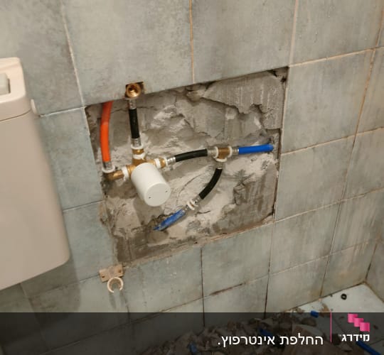 צנרת חשופה בקיר עם חיבורים וכלים